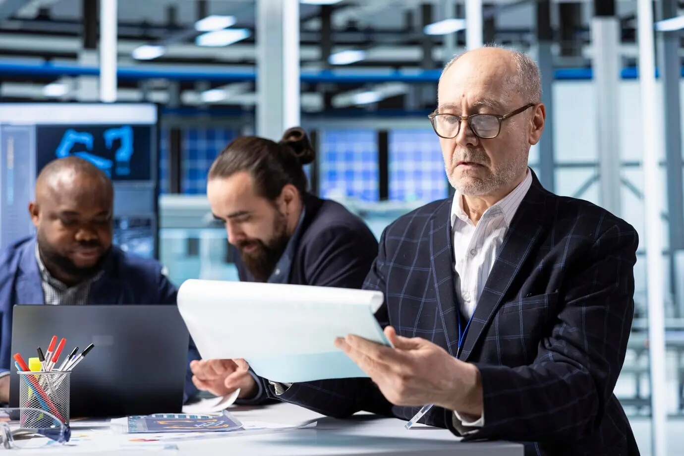 Старший акционер промышленного завода рассматривает документы, анализируя выручку.